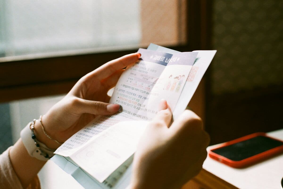 Hands holding a printed bill at a table