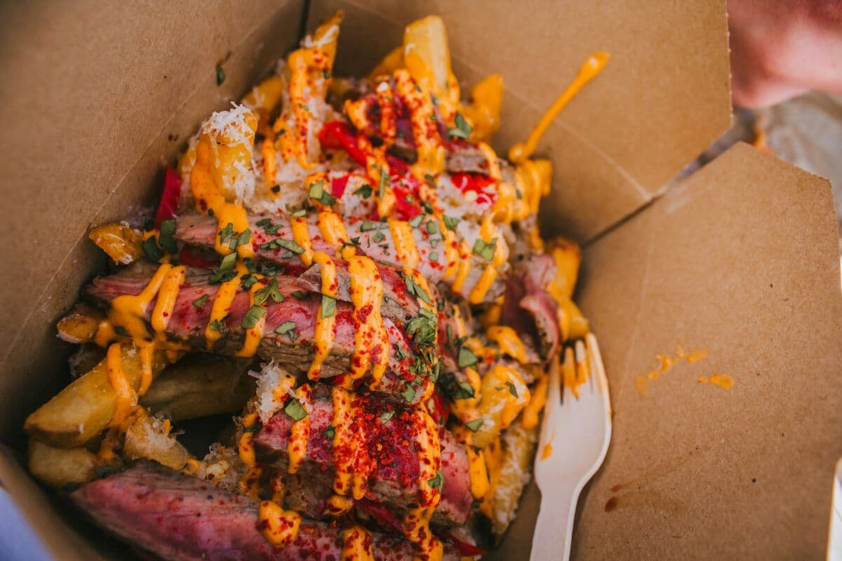 A box of loaded fries smothered in sauce and toppings