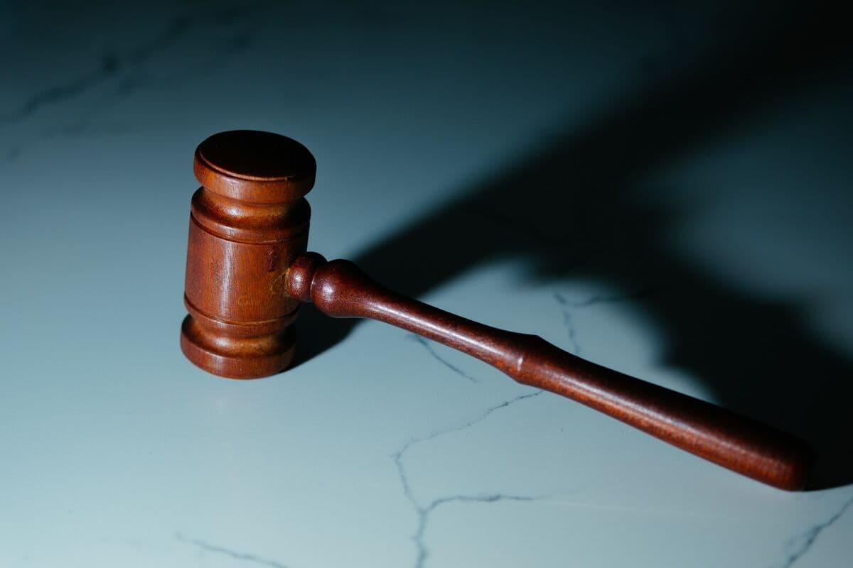 A wooden judge's gavel resting on a marble surface
