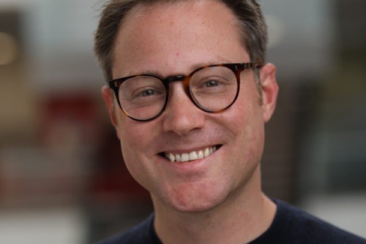 UKHospitality chief executive Allen Simpson smiling, in glasses and a dark jumper