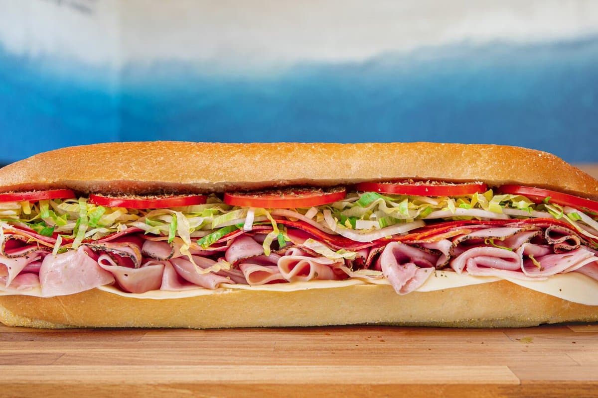 A Jersey Mike's sub piled with sliced meats, cheese, lettuce and tomato