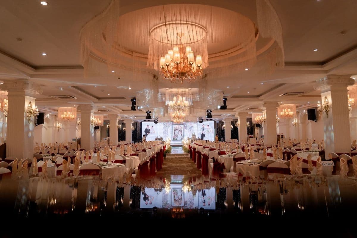 A grand ballroom set with round tables and chandeliers for an event