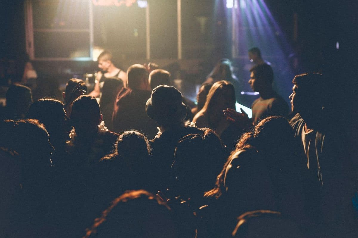 A crowd facing the stage at a concert, lit in blue