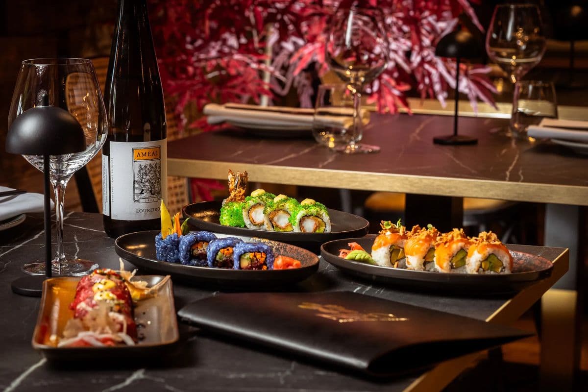 Sushi and small plates laid out on a dark table at NIPO