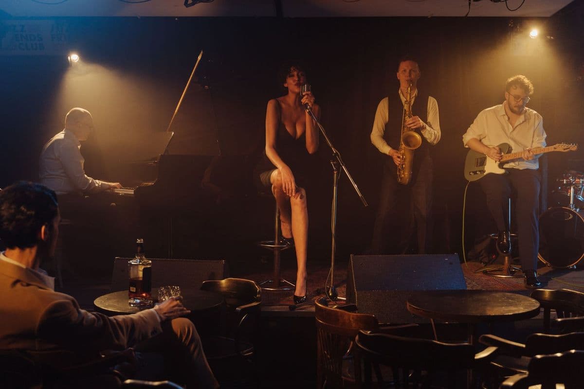 A singer performing with a band on a small stage