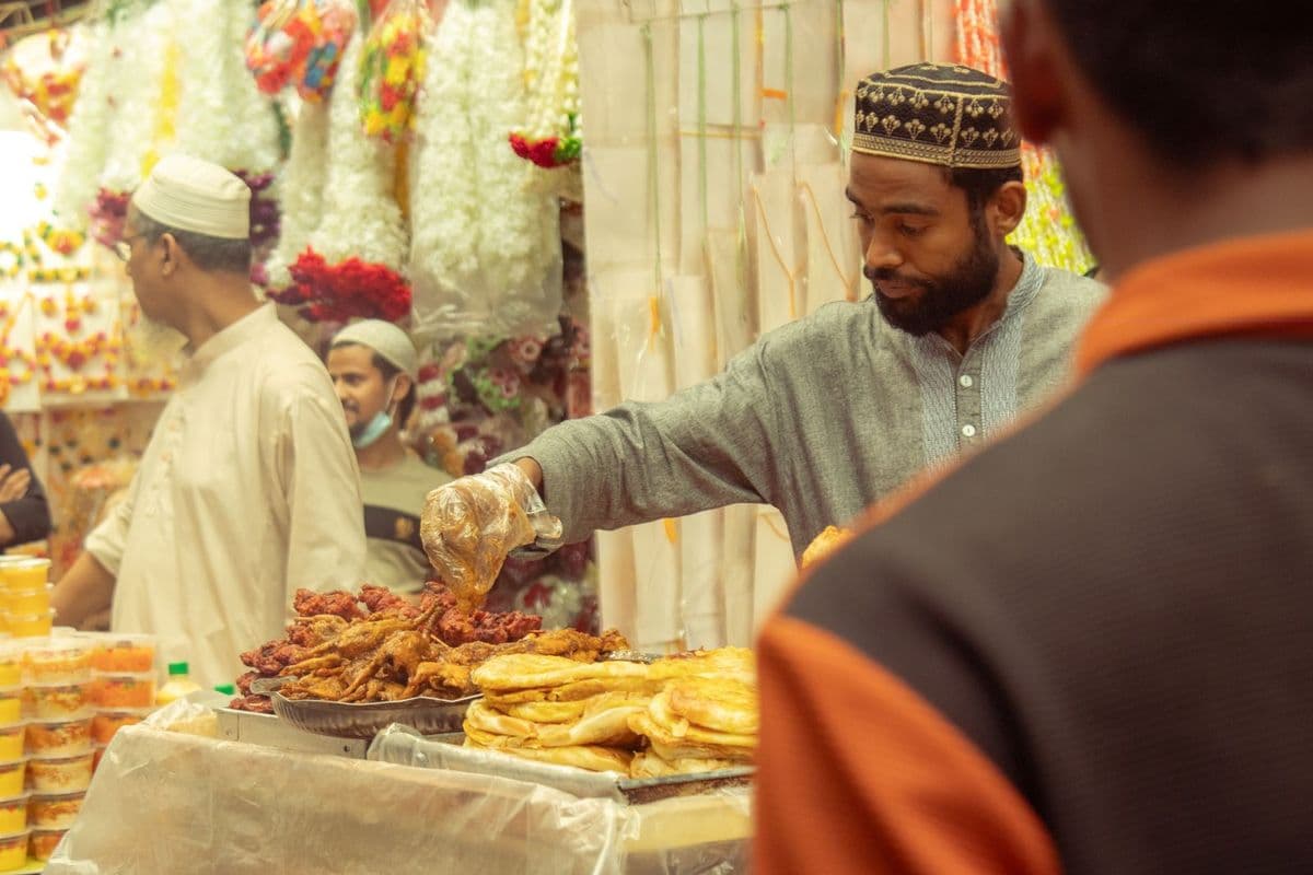A street food trader serving fried snacks from a busy stall