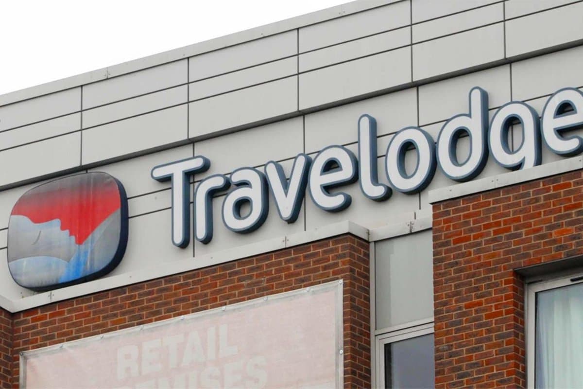 A Travelodge sign on the front of a brick hotel building