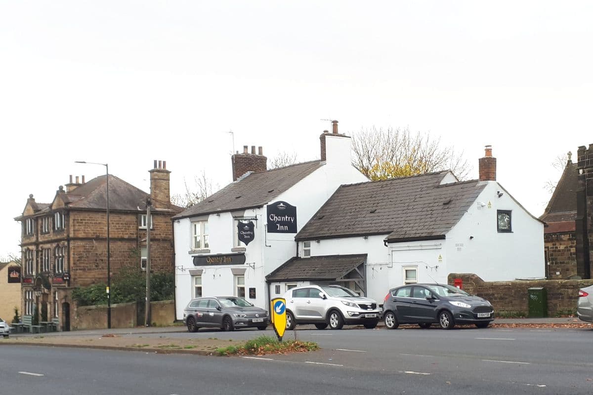 The exterior of a traditional British pub on a residential street