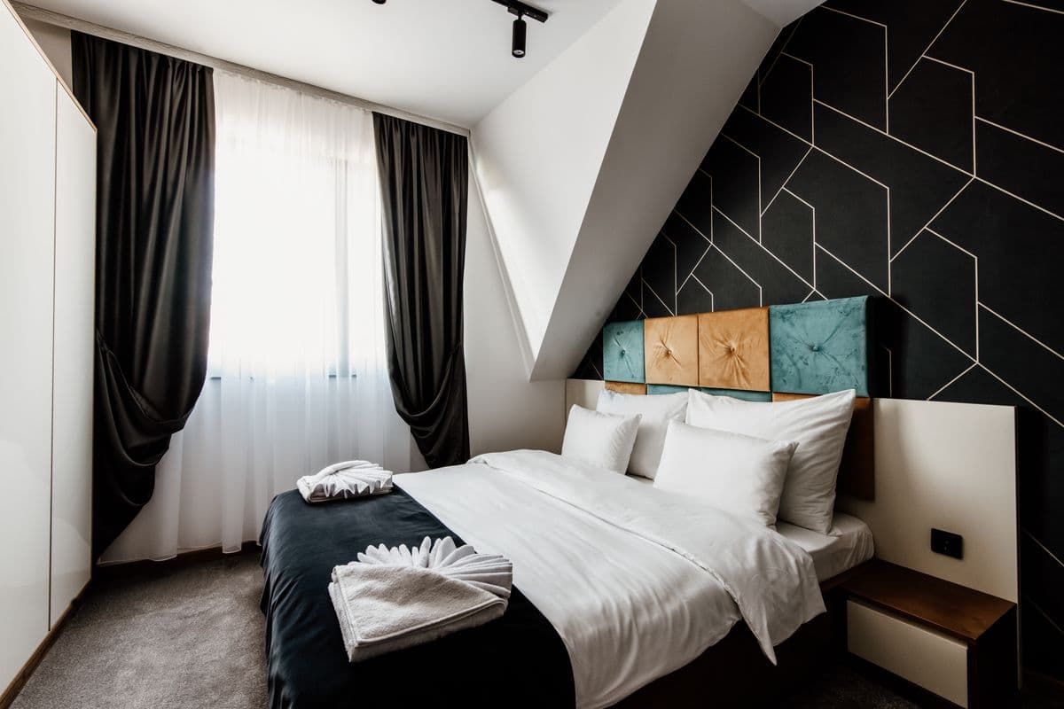 A modern hotel bedroom with neat bedding and soft daylight
