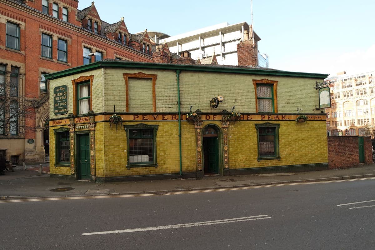 The green-tiled Peveril of the Peak pub on a Manchester street corner