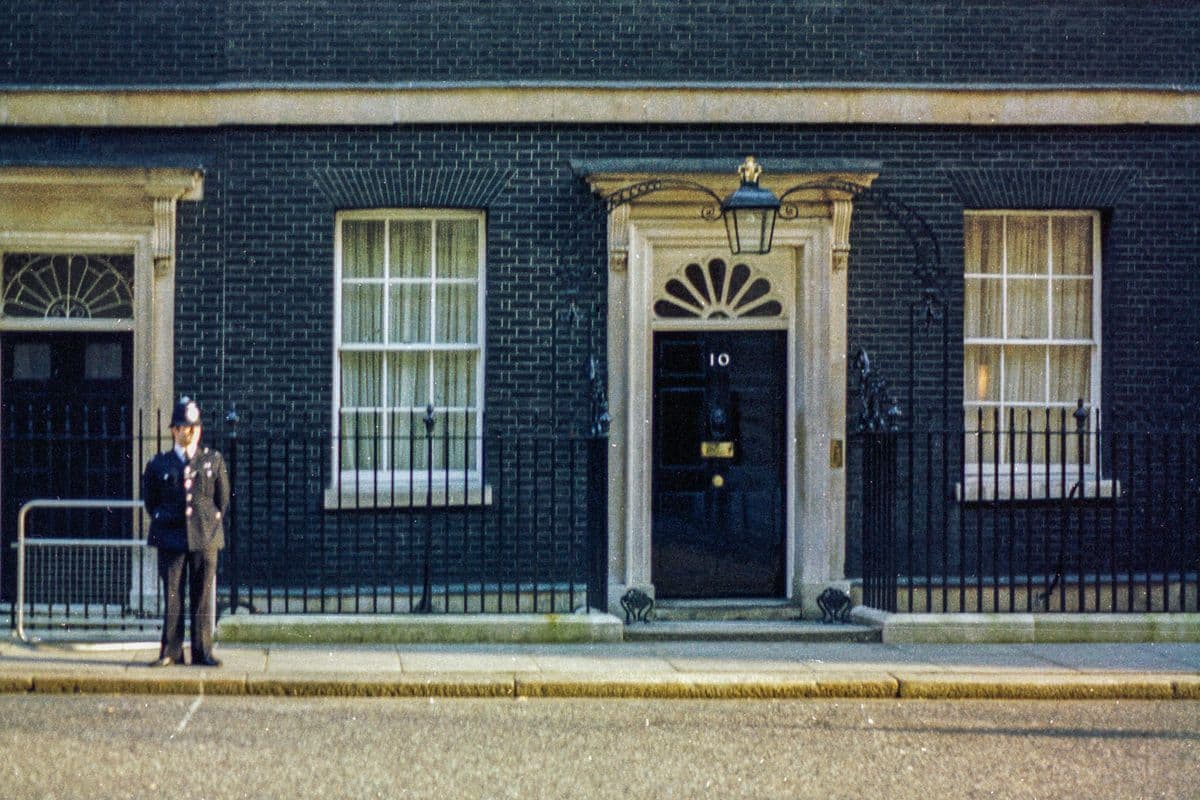 The black front door of 10 Downing Street with a police officer outside