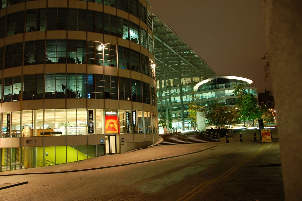 A Wagamama restaurant with a curved glass front, lit up at night