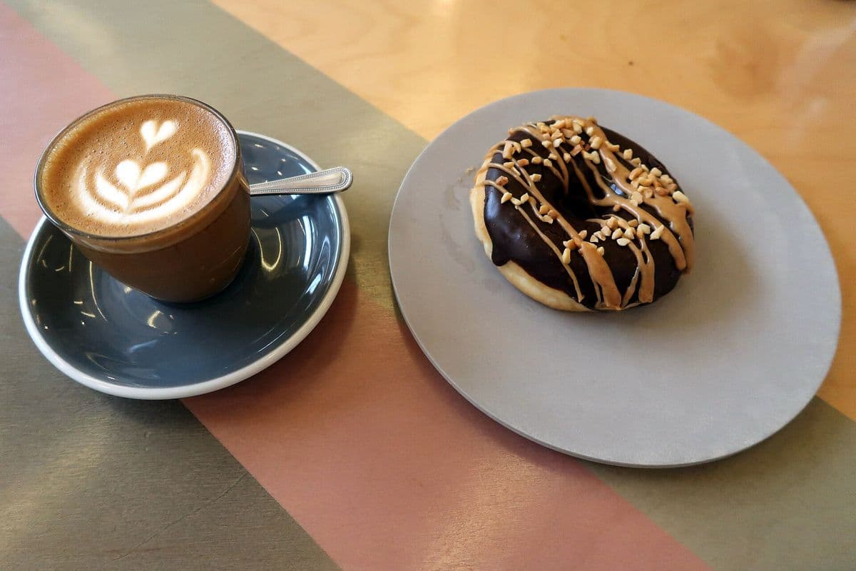 A barista preparing coffee behind a cafe counter