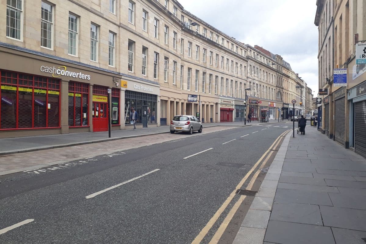 Clayton Street in Newcastle city centre with a row of shops and sandstone buildings