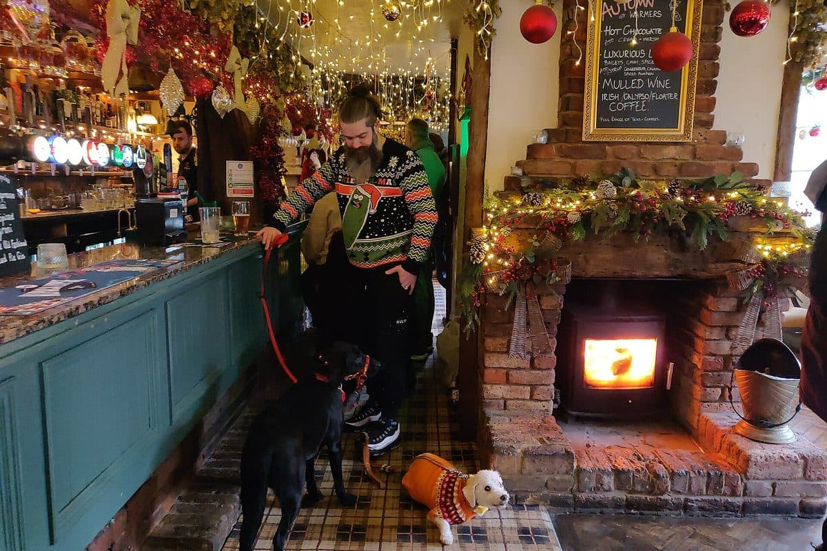 A pub bar decorated for Christmas, with a log burner lit