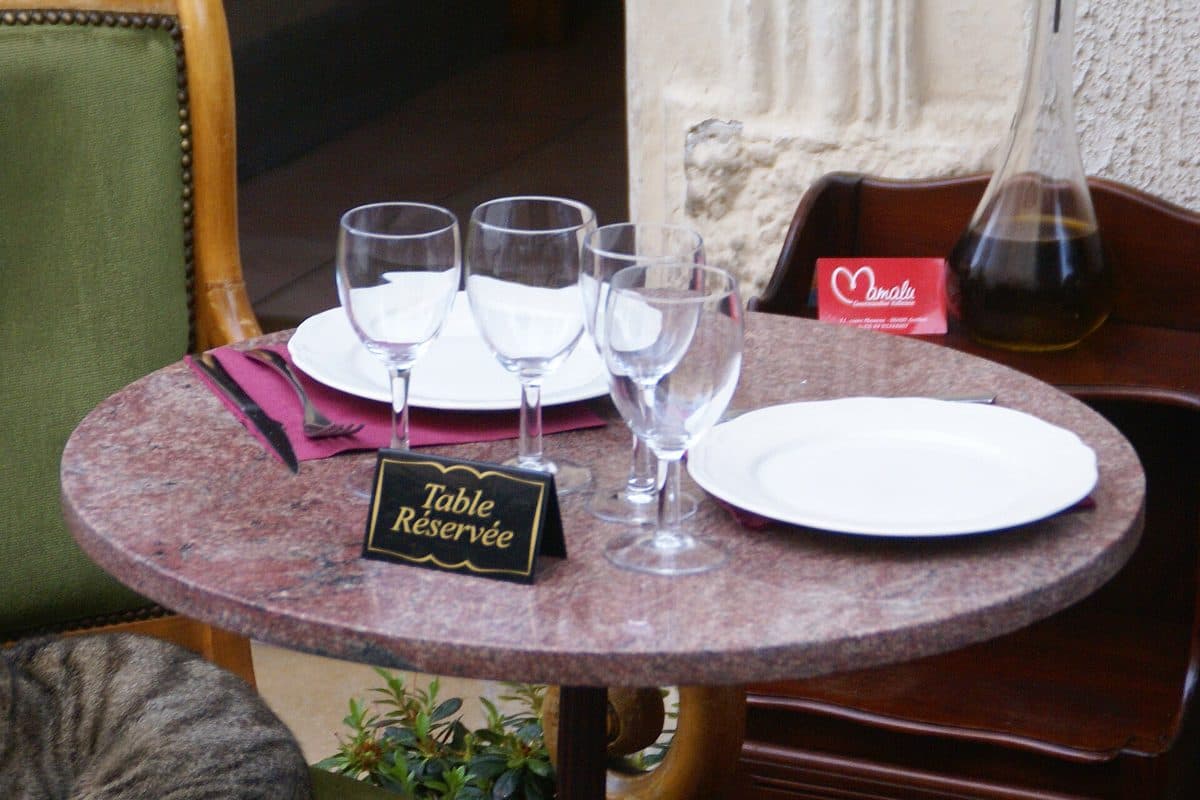 A restaurant table laid for two with a reserved sign