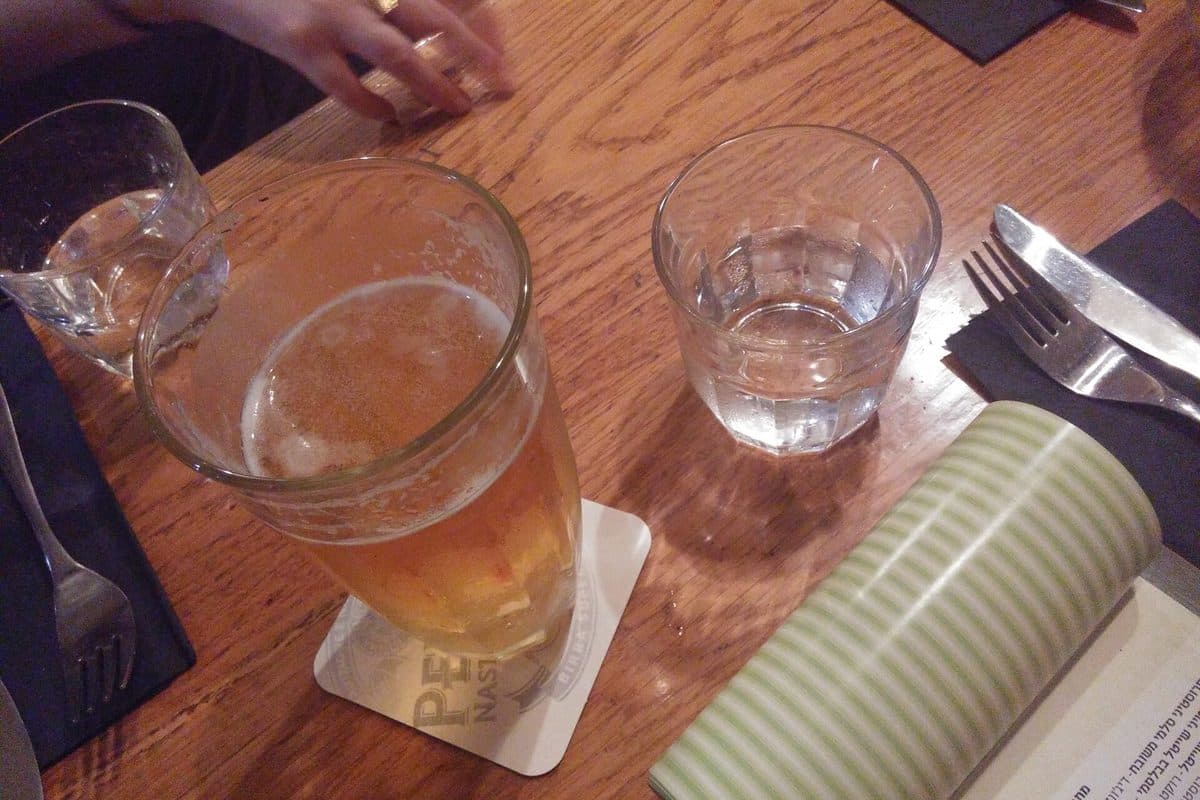 A glass of beer on a wooden pub table