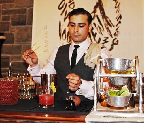 A bartender stirring a classic cocktail at the bar