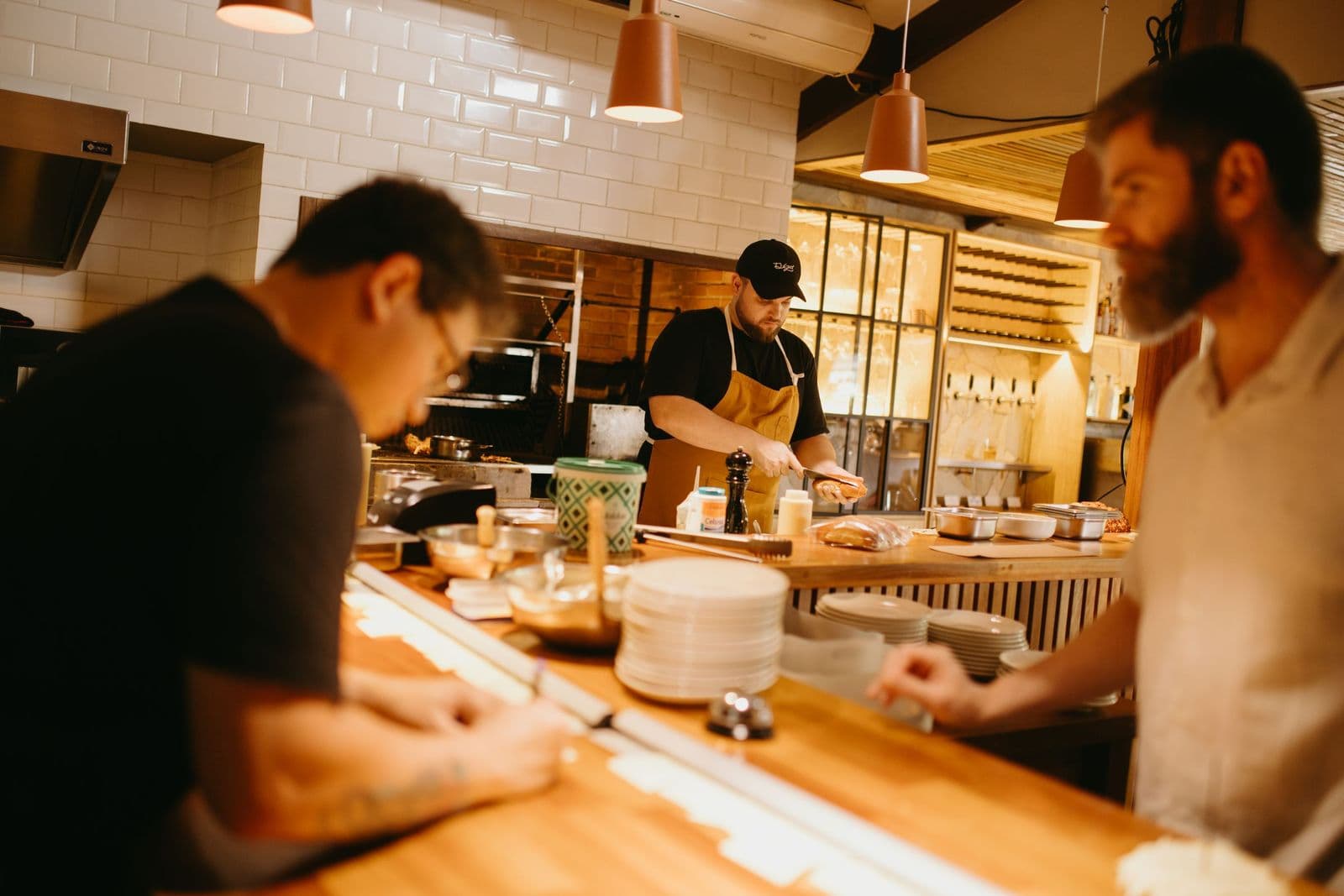 Three chefs working side by side in a restaurant kitchen