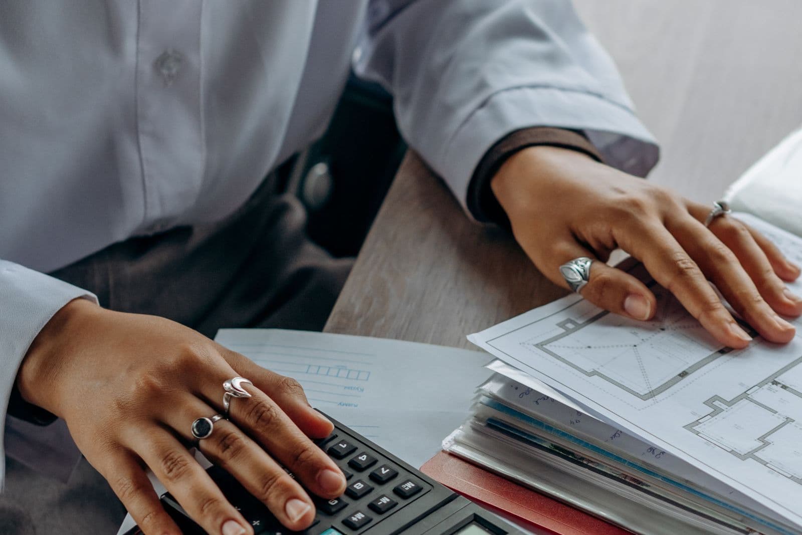 Person working through paperwork with a calculator