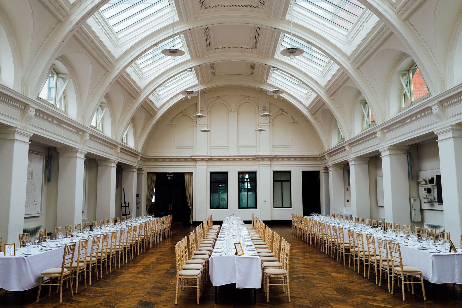 Long tables laid for a formal event in a large dining hall