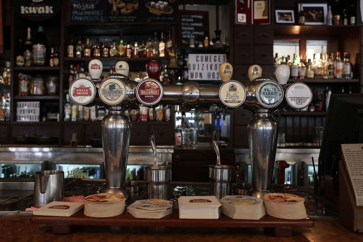A row of beer taps on a pub bar