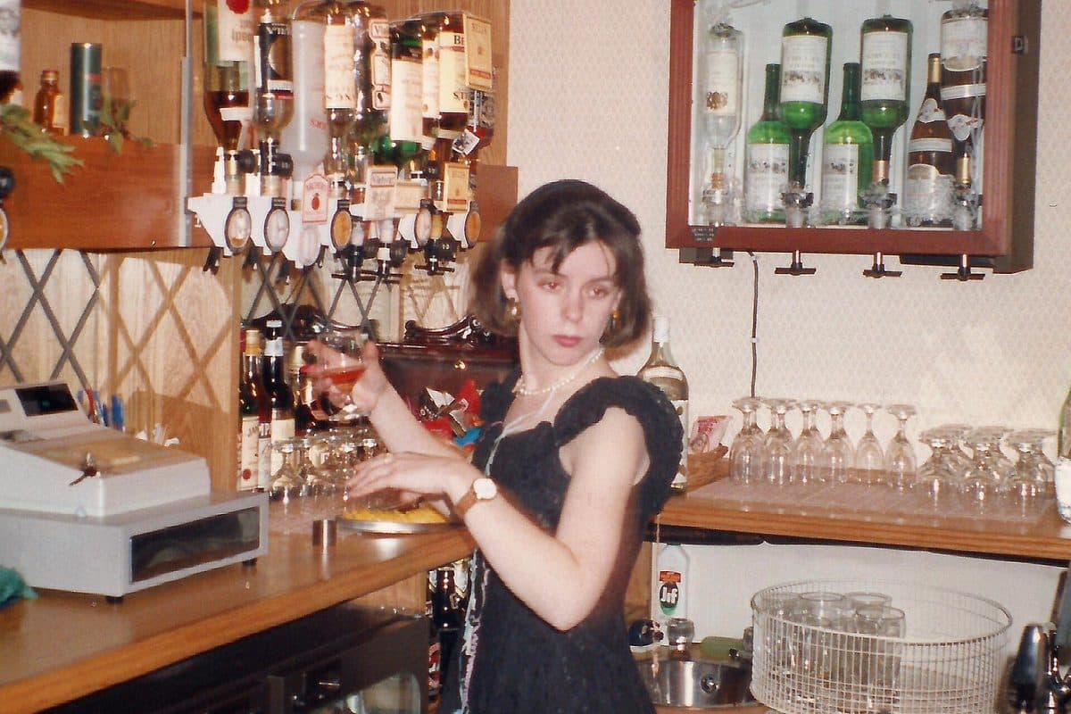 A bartender pouring a drink behind a pub bar