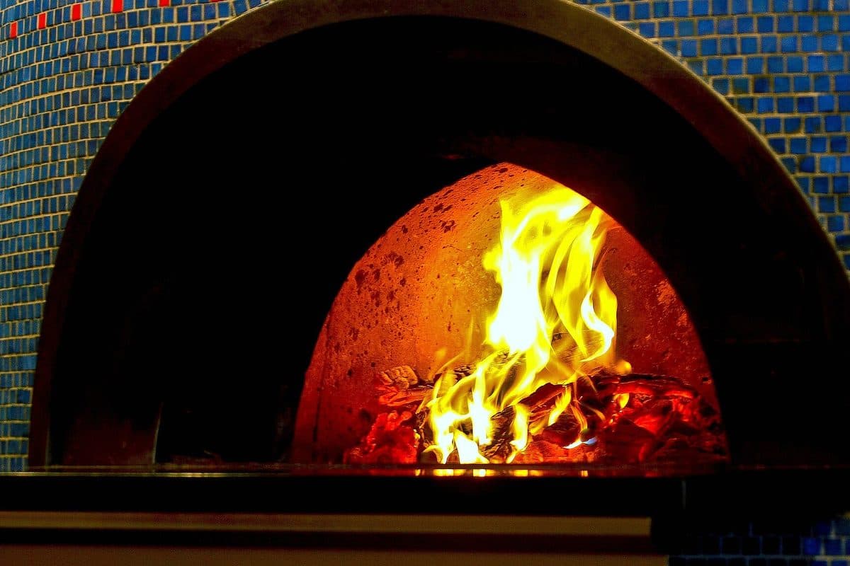 Flames inside a tiled wood-fired pizza oven