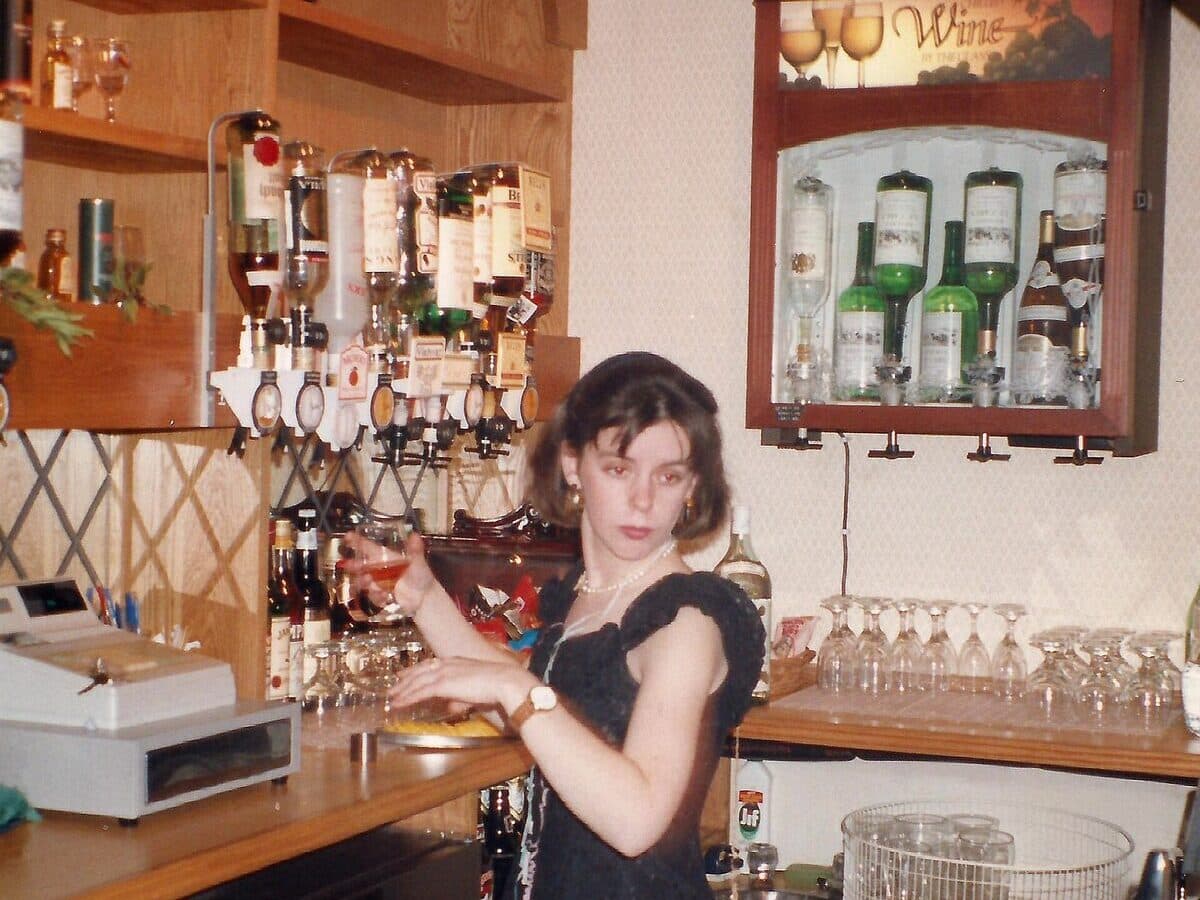 A bartender pouring a drink behind a well-stocked bar