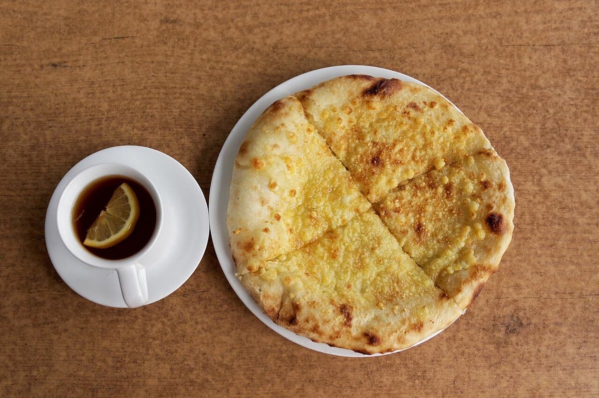 A Georgian khachapuri with egg and butter in a cheese-filled bread boat