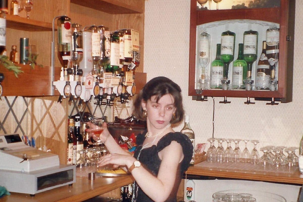 A bartender pulling a drink behind a pub bar in the UK