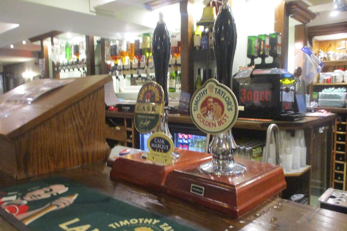 Beer pumps lined up on a pub bar