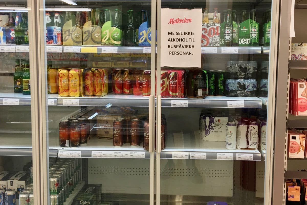 Bottles and cans of beer in a shop's glass-door fridge