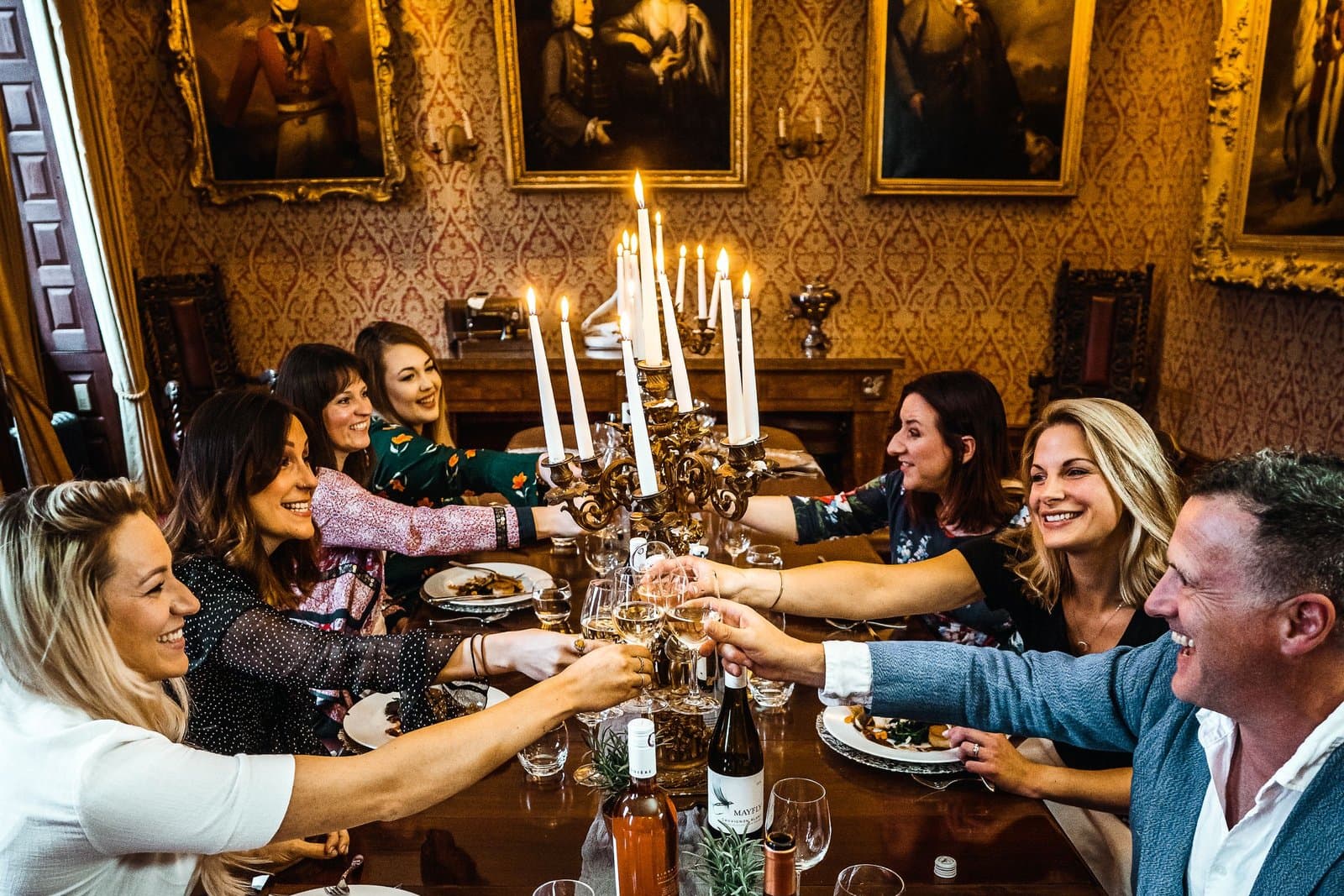 A group of friends raising a toast around a dinner table
