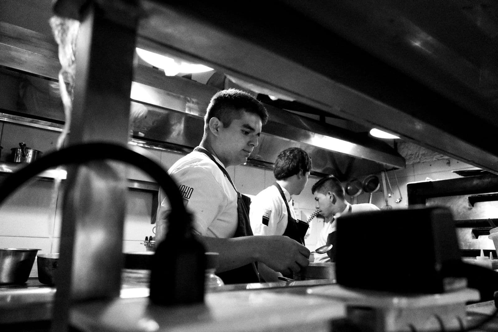 Chefs working together in a professional kitchen, black and white