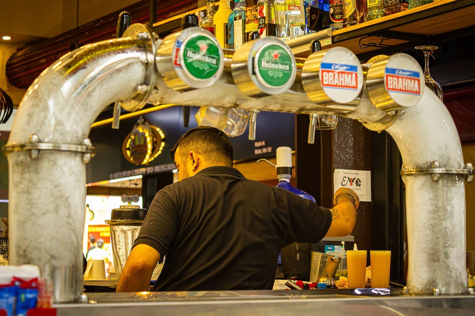 A bartender serving drinks at a busy bar