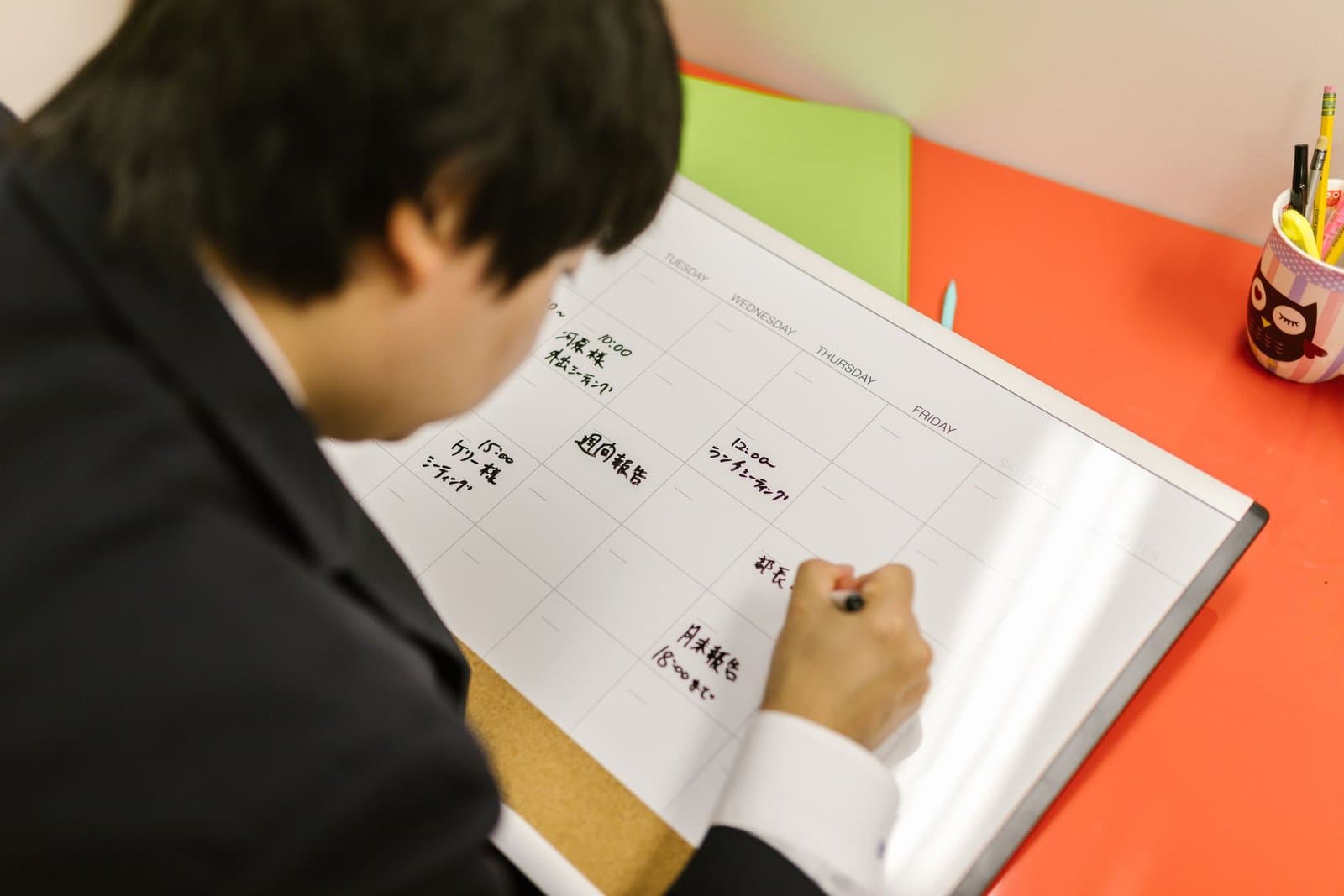 Manager writing shifts on a weekly planner board