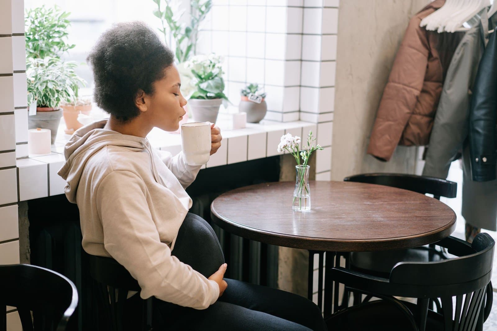 A pregnant woman with a cup of coffee in a cafe