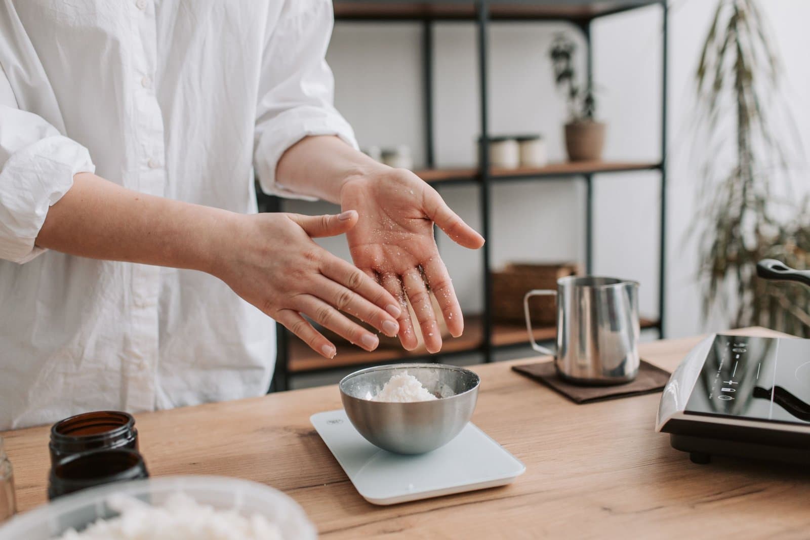 Hands weighing an ingredient on a kitchen scale