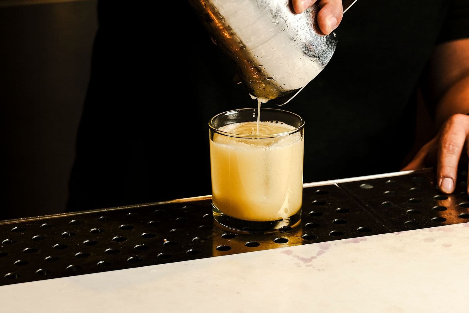 Bartender pouring a cocktail on the bar